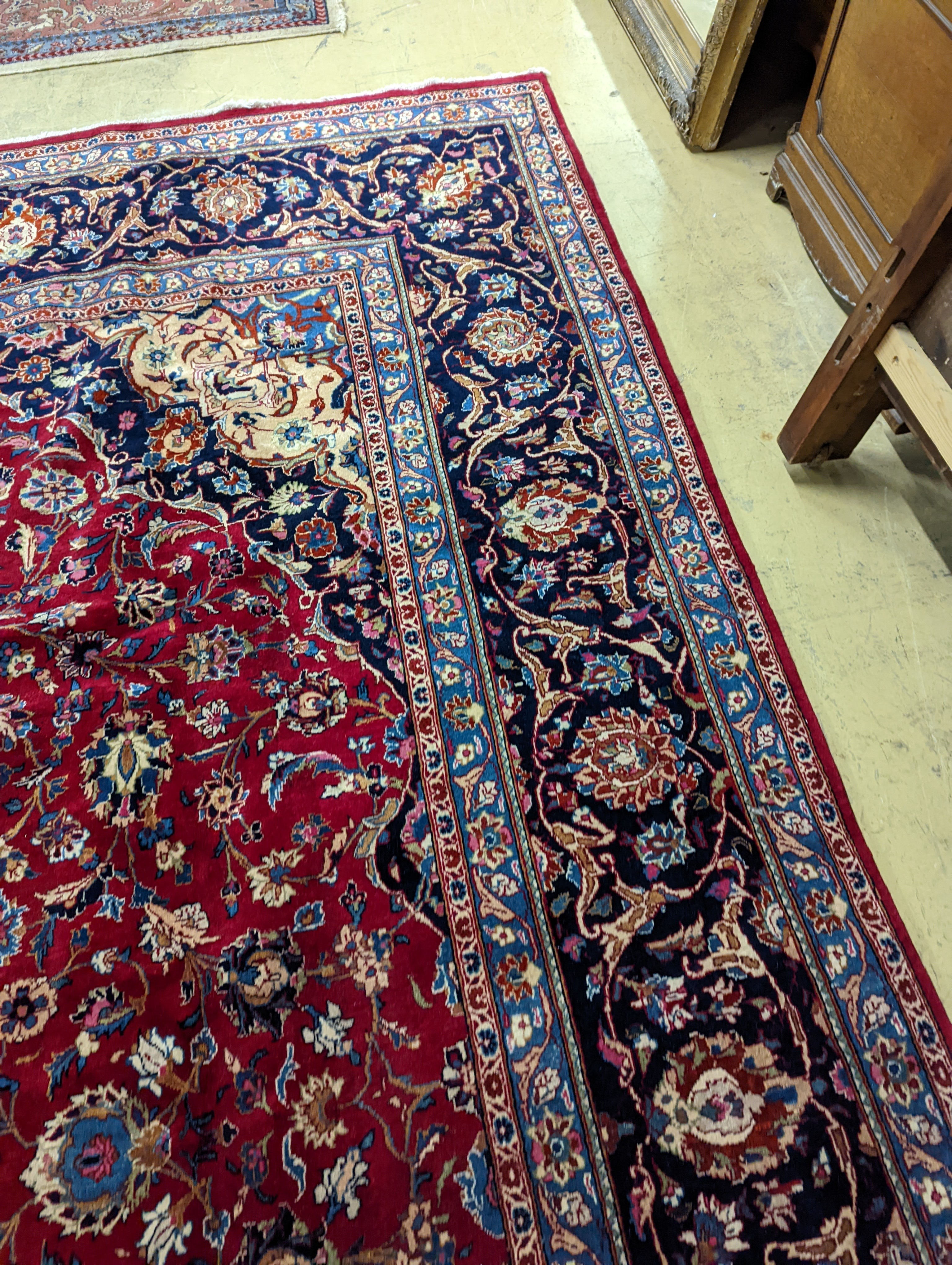 A Kashan burgundy ground carpet, 380 x 300cm